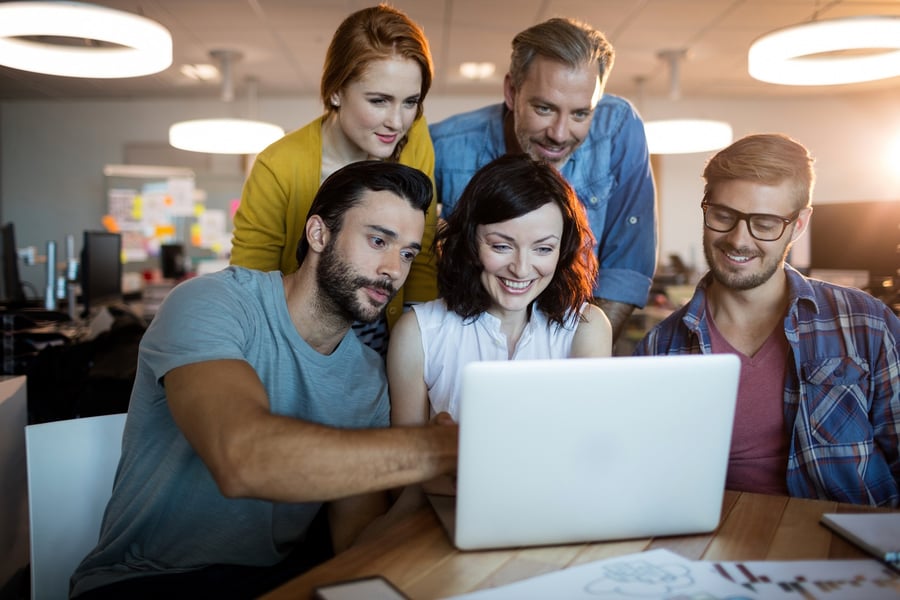 Happy business team discussing over the laptop in office